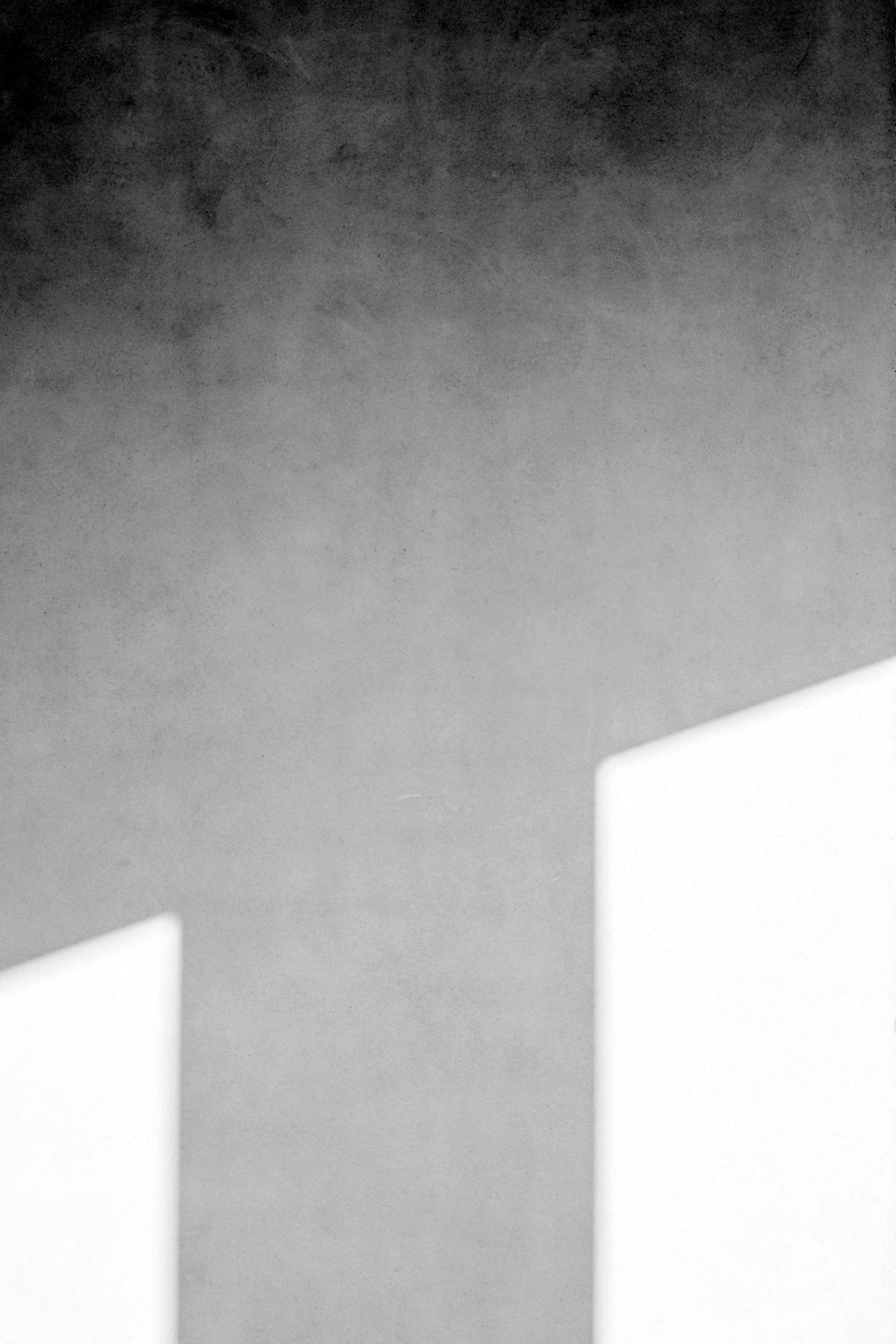 Mur enduit traversé par la lumière, jeu d'ombres géométriques